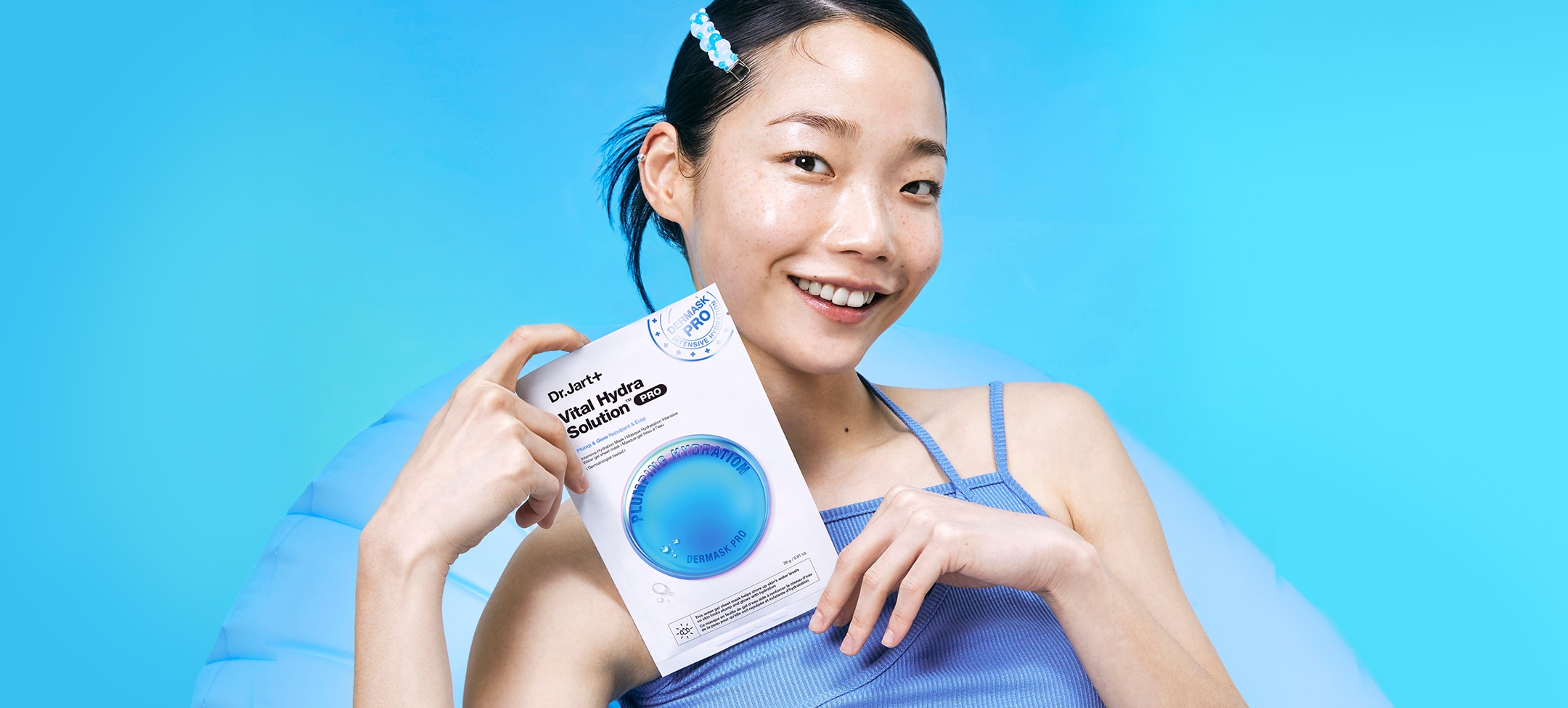 Woman with glowing moisturized skin holds Dr.Jart+'s moisturizing face mask